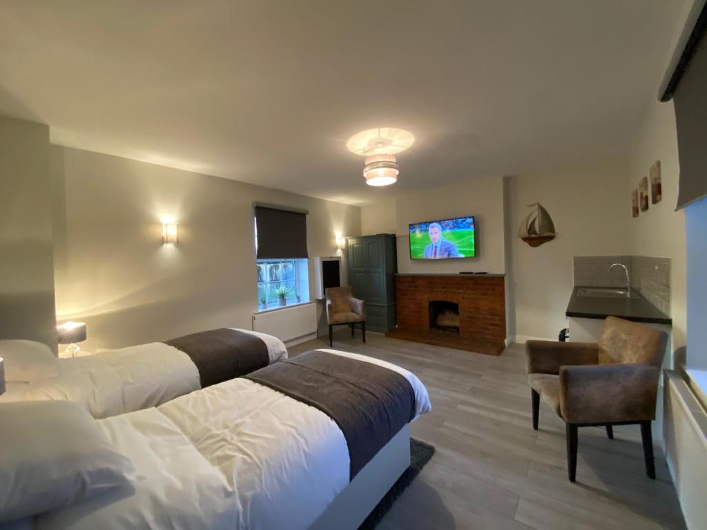 a hotel room with two beds and a flat screen tv at The Fordham Inn in Sharnbrook