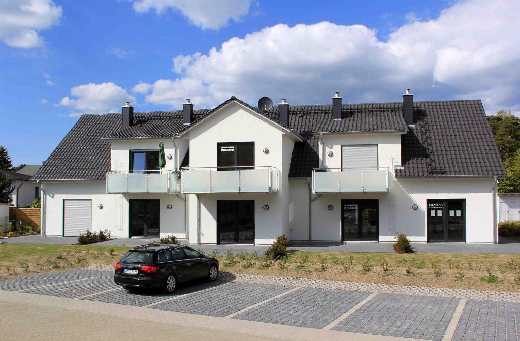 a car parked in a parking lot in front of a house at Haus Düne Whg 03 mit SüdWest Terrasse und Balkon in Thiessow