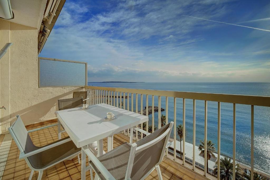 un balcon avec une table et des chaises et l'océan dans l'établissement IMMOGROOM - Panoramic View - quiet - AC - bright, à Cannes
