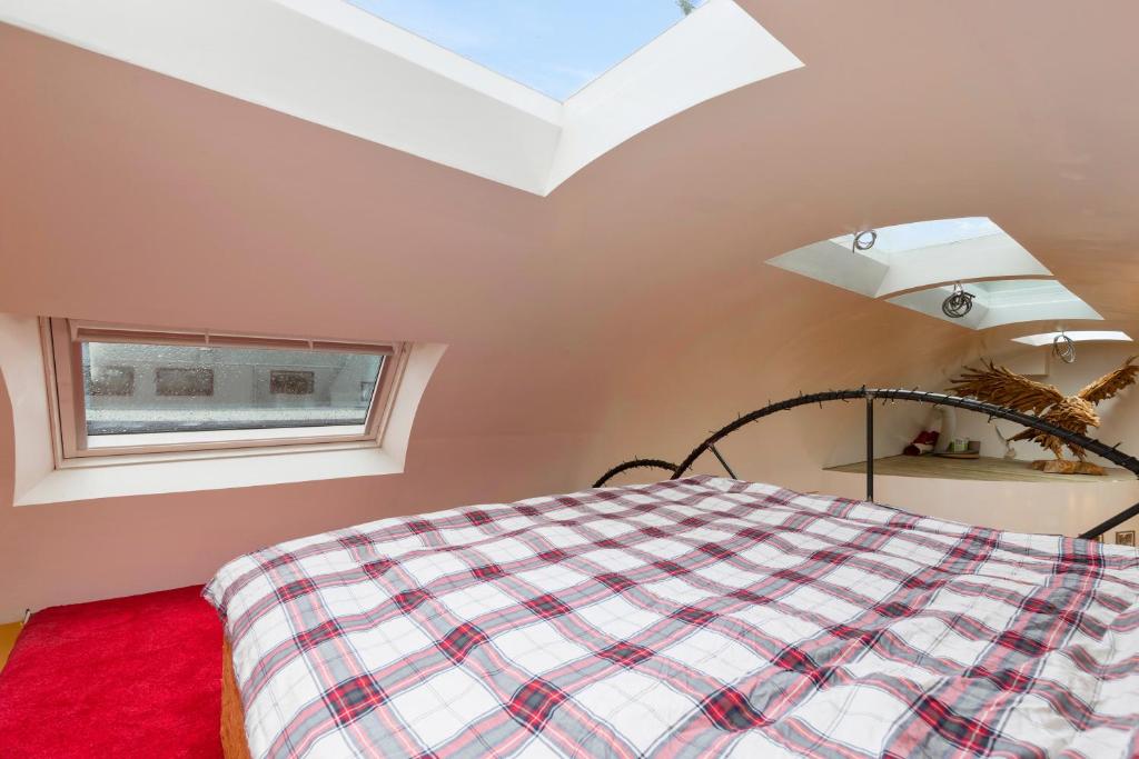 een slaapkamer met een bed en een dakraam bij B&B Houseboat Amsterdam in Amsterdam