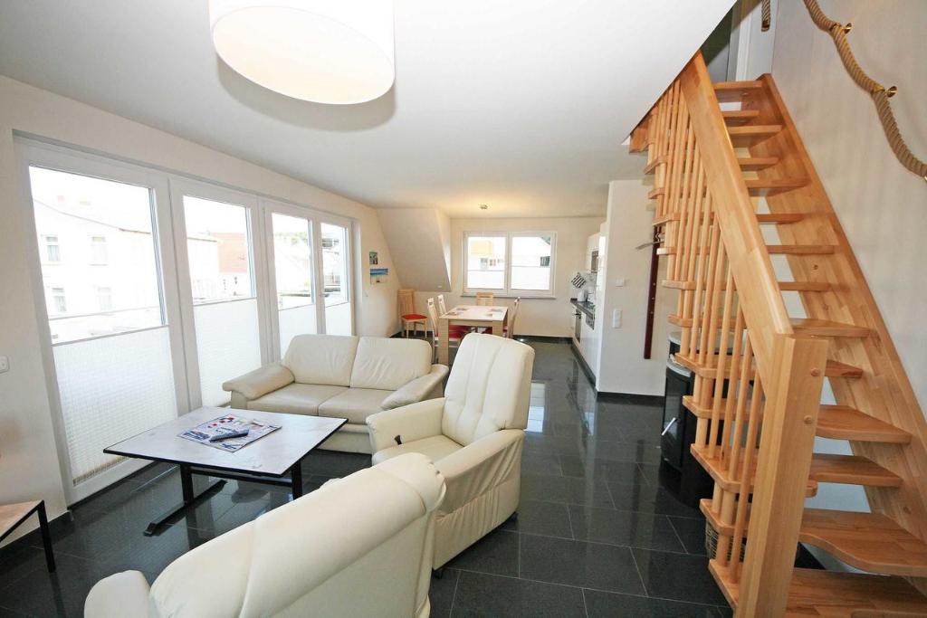 a living room with white furniture and a staircase at Haus Sanddorn Whg 05 mit 2 Balkone in Thiessow