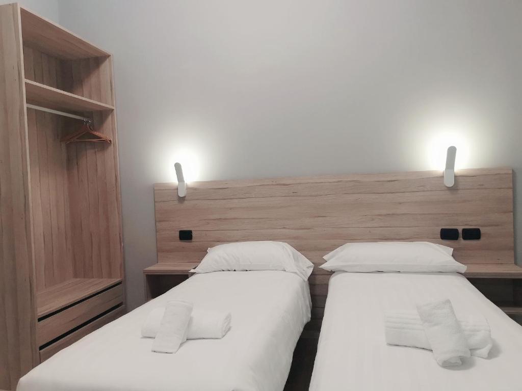 2 camas individuales en un dormitorio con cabecero en Miu Hotel en Milán