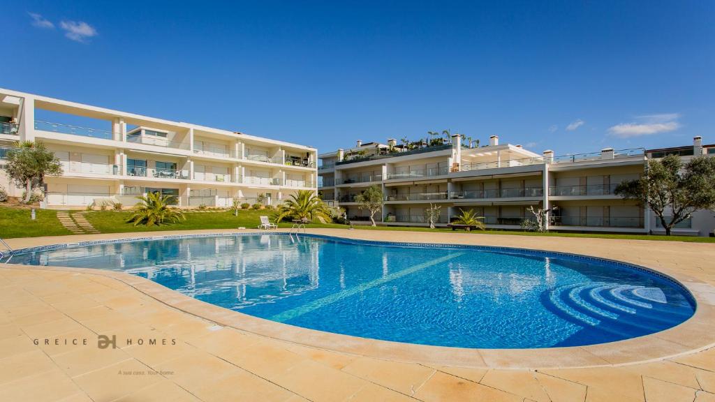 een groot zwembad voor een gebouw bij Greice Homes-Apartamento 2 quartos, Monte da Balaia, Olhos de Água, Albufeira in Olhos de Água