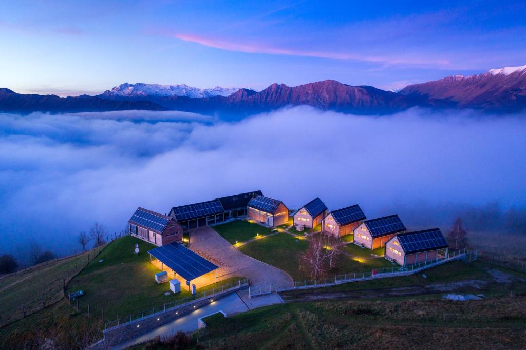 a house on top of a hill in the clouds at Nebesa Chalets in Kobarid