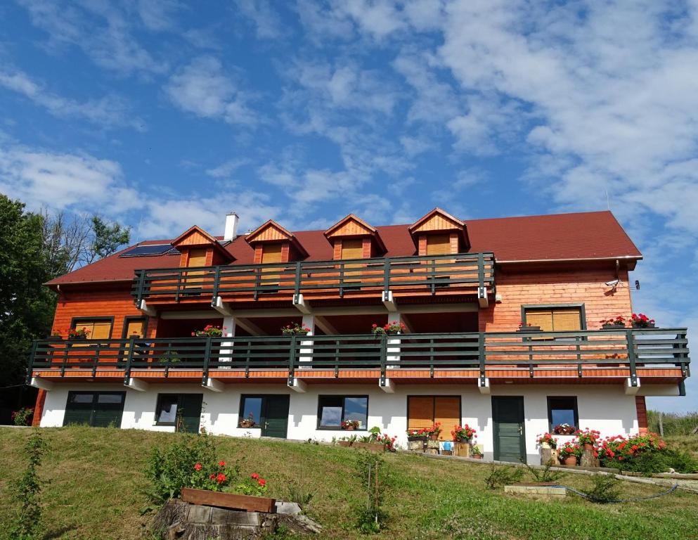 a large building with balconies on top of a hill at Rejtek Vendégház in Lispeszentadorján