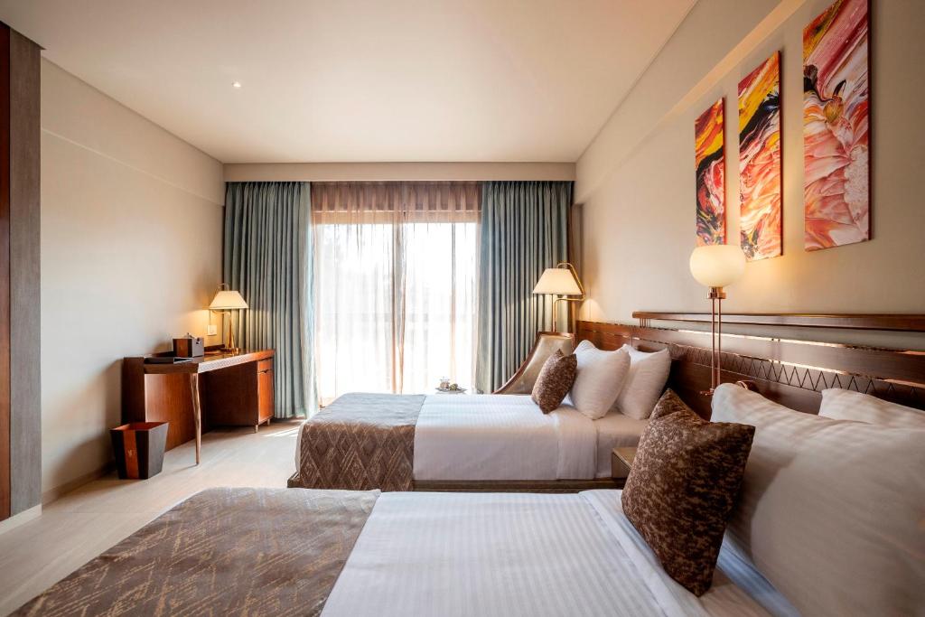 Postel nebo postele na pokoji v ubytování YU Hotel Candolim