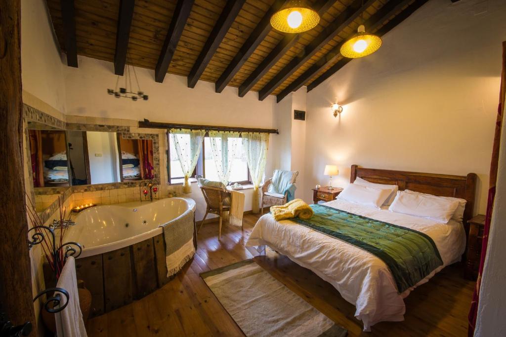 Schlafzimmer mit einem Bett und einer Badewanne in der Unterkunft Casa rural La Tenada in Los Narros