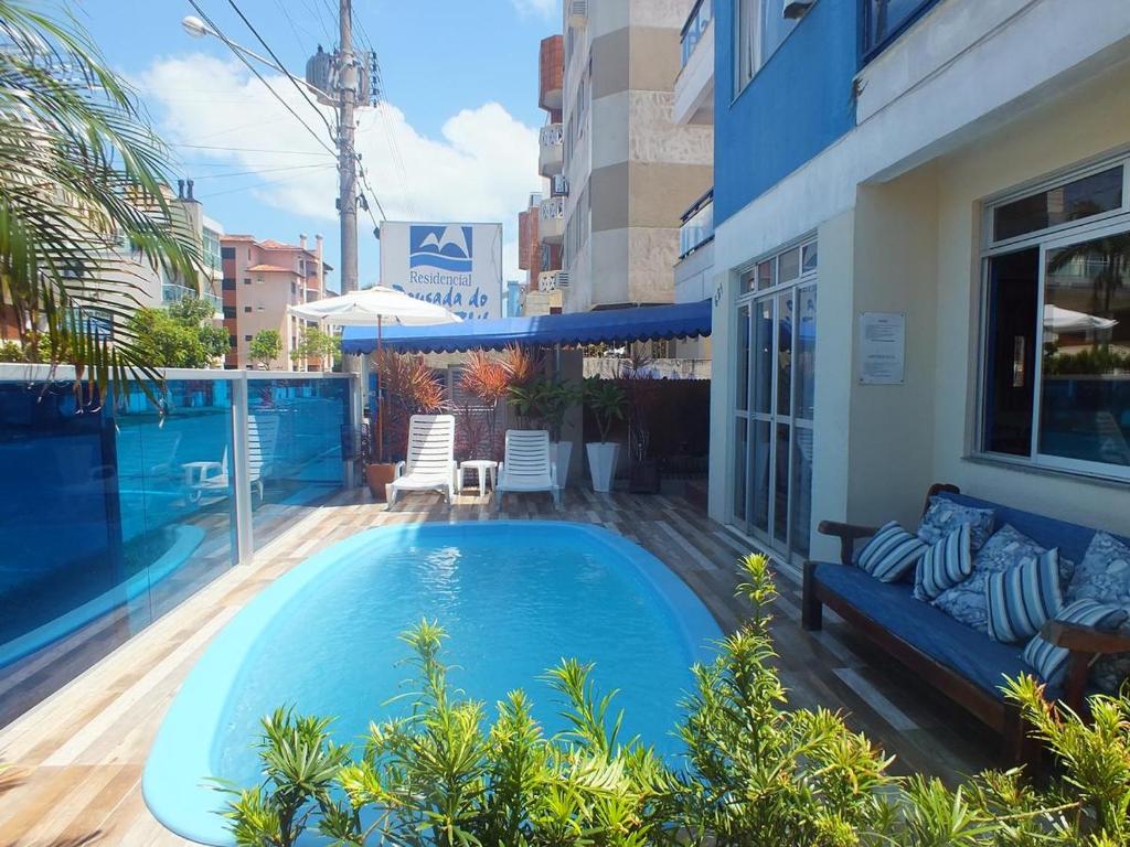 a swimming pool with a couch next to a building at Residencial Praia Mar in Florianópolis