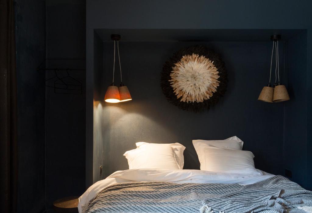 HO36 Hostel في ليون: غرفة نوم بجدران زرقاء وسرير بمخدات بيضاء