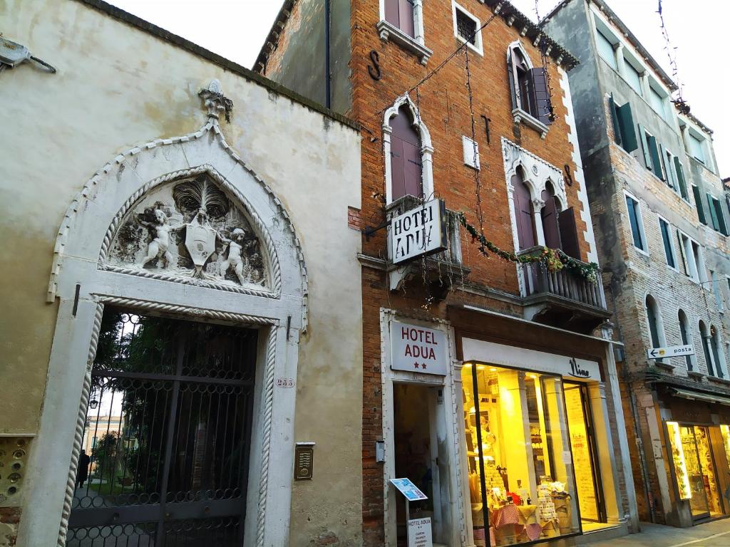 a building with a sign on the side of a street at Hotel Adua in Venice