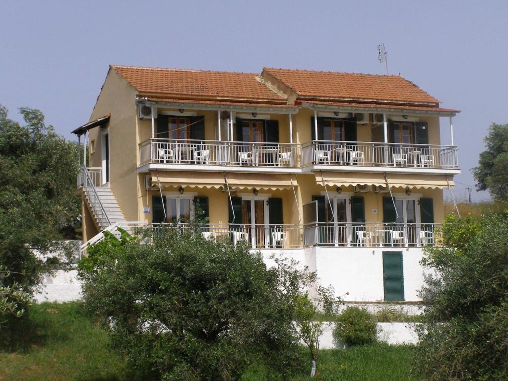 a large yellow house with a balcony at Evridiki Apartments in Mesongi