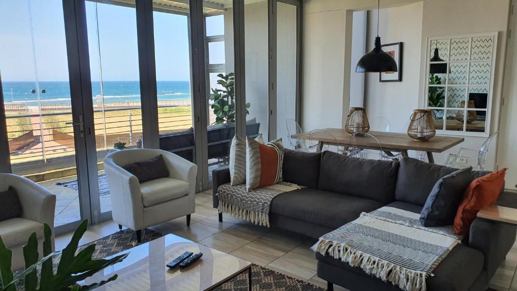 a living room with a couch and a view of the ocean at Accommodation Front - Gorgeous 4 Sleeper Beachfront Apartment in Durban