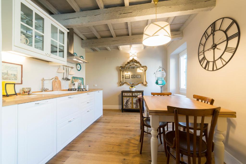 a kitchen with a table and a clock on the wall at Oltrarno Real Mood Florentine Apartment in Florence