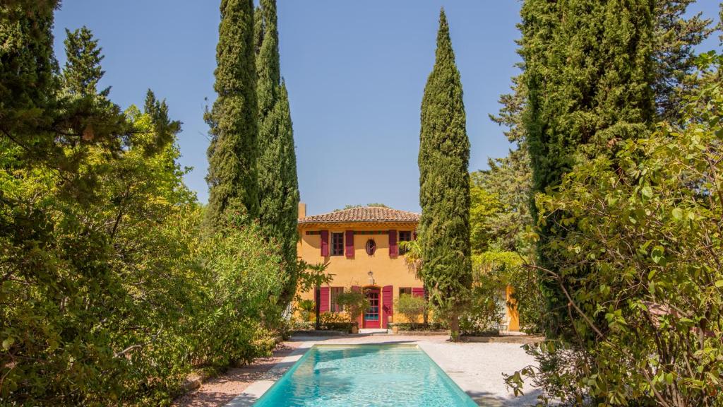 une villa avec une piscine au milieu des arbres dans l'établissement Le Pigonnet - Esprit de France, à Aix-en-Provence