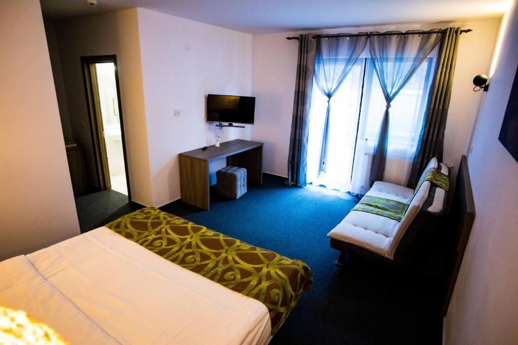 ein Hotelzimmer mit 2 Betten und einem TV in der Unterkunft Pensiunea Bradului in Colibiţa