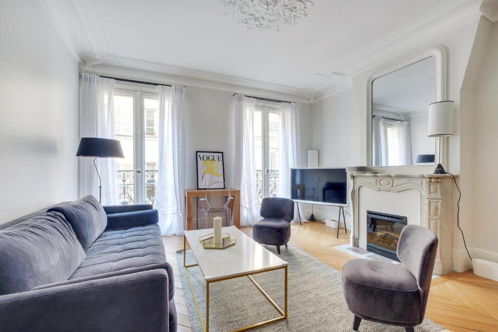 a living room with a couch and chairs and a fireplace at Elegant Family Apt 5 pers - Bon Marché in Paris