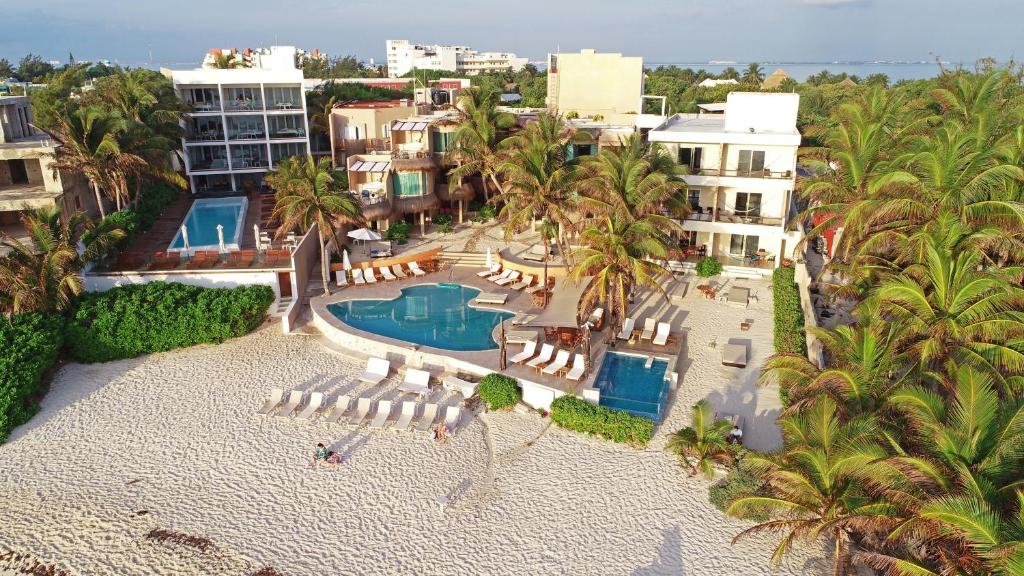 an aerial view of a resort with a pool and chairs and palm trees at Hotel Playa La Media Luna in Isla Mujeres