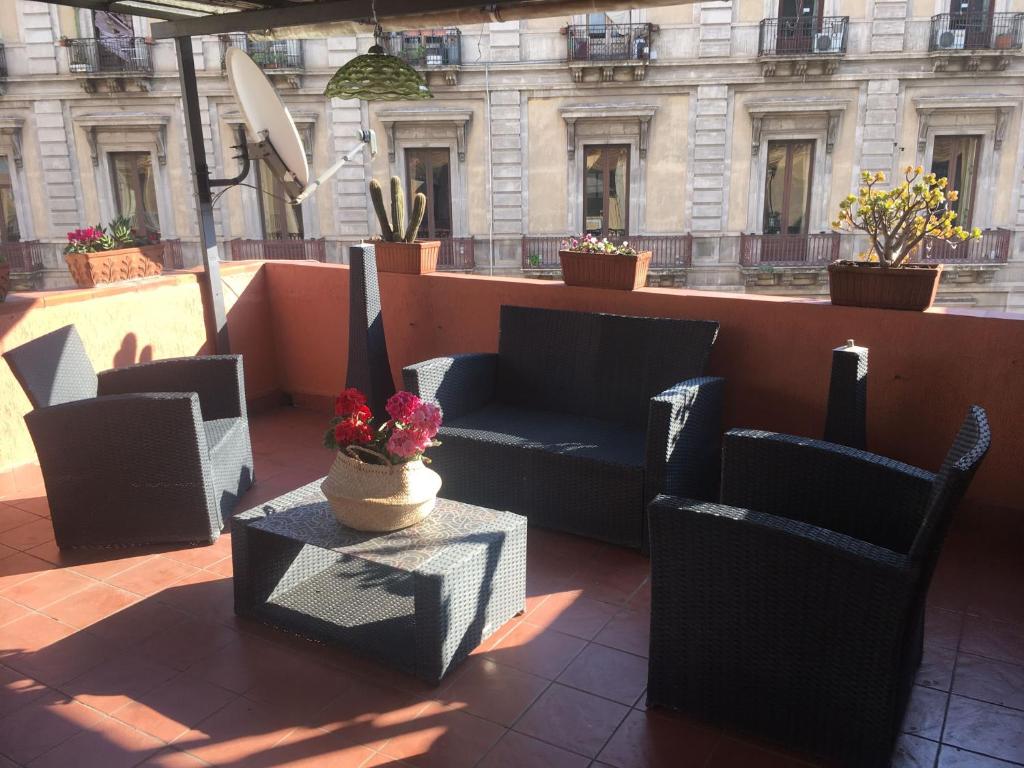 un patio con sedie, divano e tavolo di La Mansarda-roof a Catania