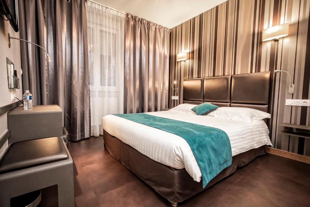 a bedroom with a large bed and a window at Hôtel d'Orléans in Orléans