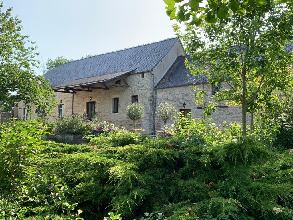 Holiday home Haras du Ry في Brévands: منزل حجري قديم وامامه حديقة
