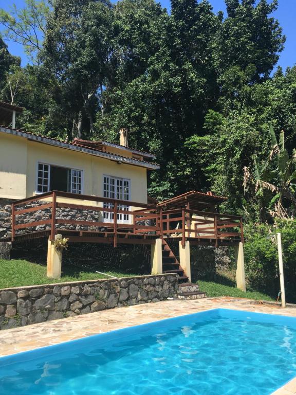 a house and a swimming pool in front of a house at Pousada Casa da Montanha in Angra dos Reis