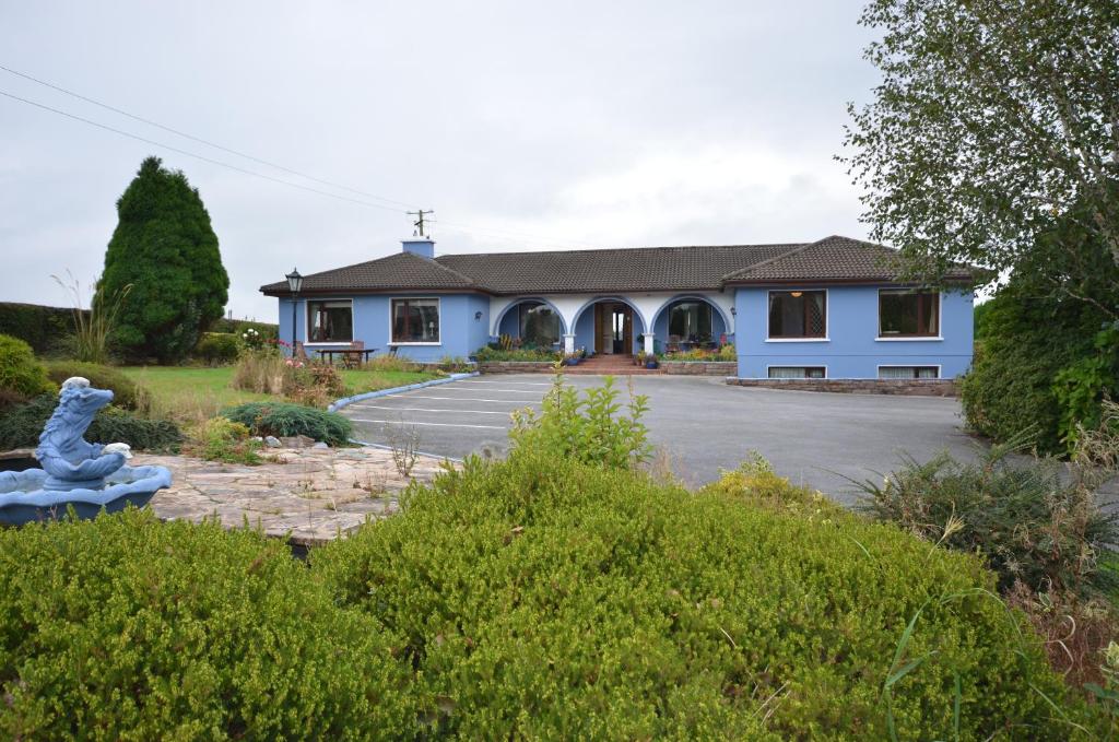 a blue building with a statue in front of it at Gormans Country Home in Killarney