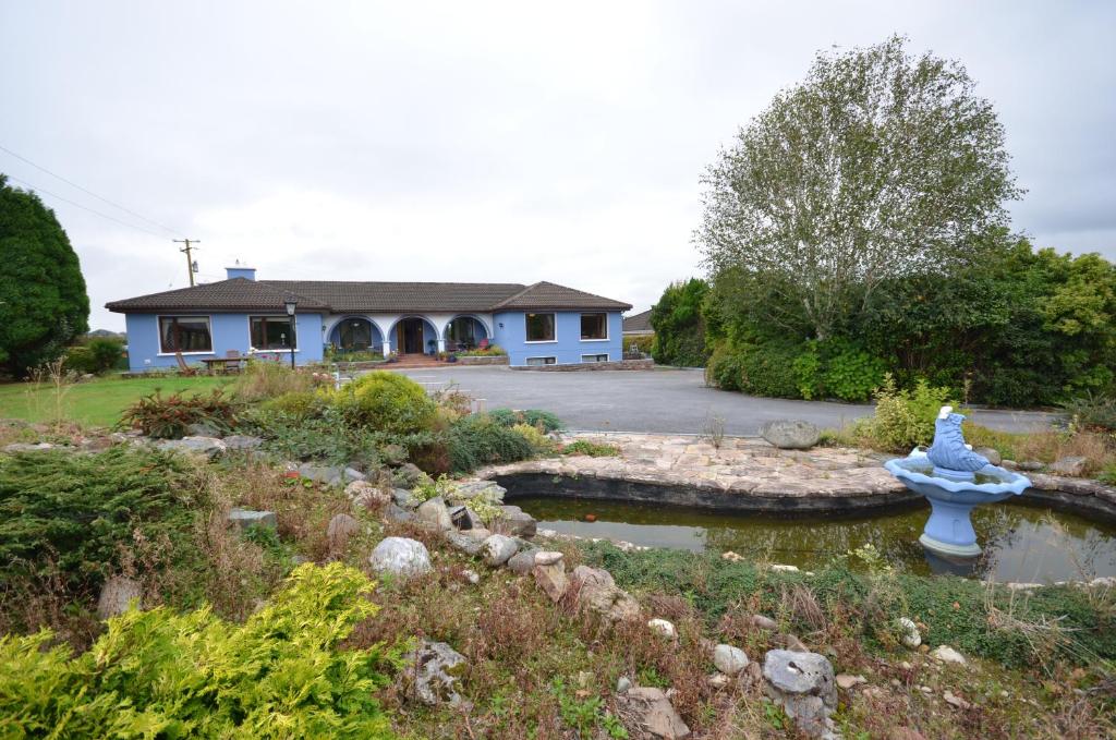 a blue fountain in a garden in front of a house at Gormans Country Home in Killarney