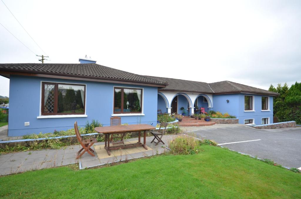 a blue house with a picnic table in the yard at Gormans Country Home in Killarney