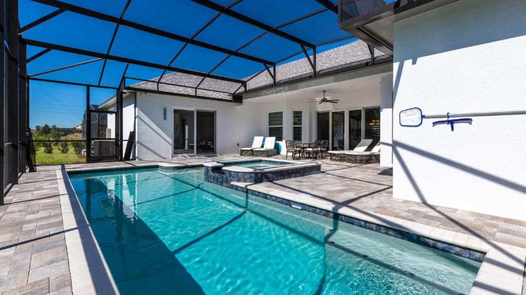 Paradise at Providence - Exclusive 4 bed pool home في أورلاندو: مسبح في بيت بسقف زجاجي