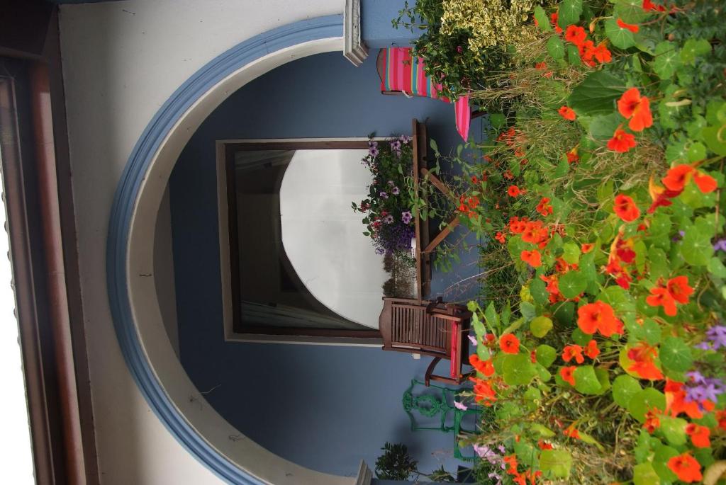 a mirror on a wall with flowers and plants at Gormans Country Home in Killarney