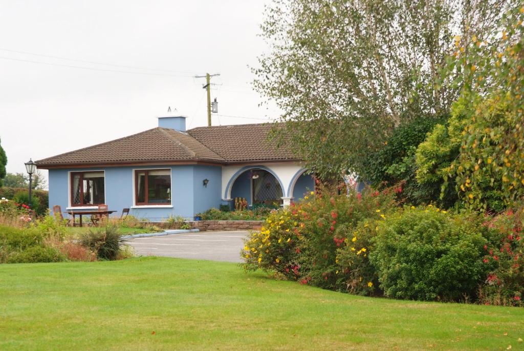 a blue house with a grassy yard at Gormans Country Home in Killarney