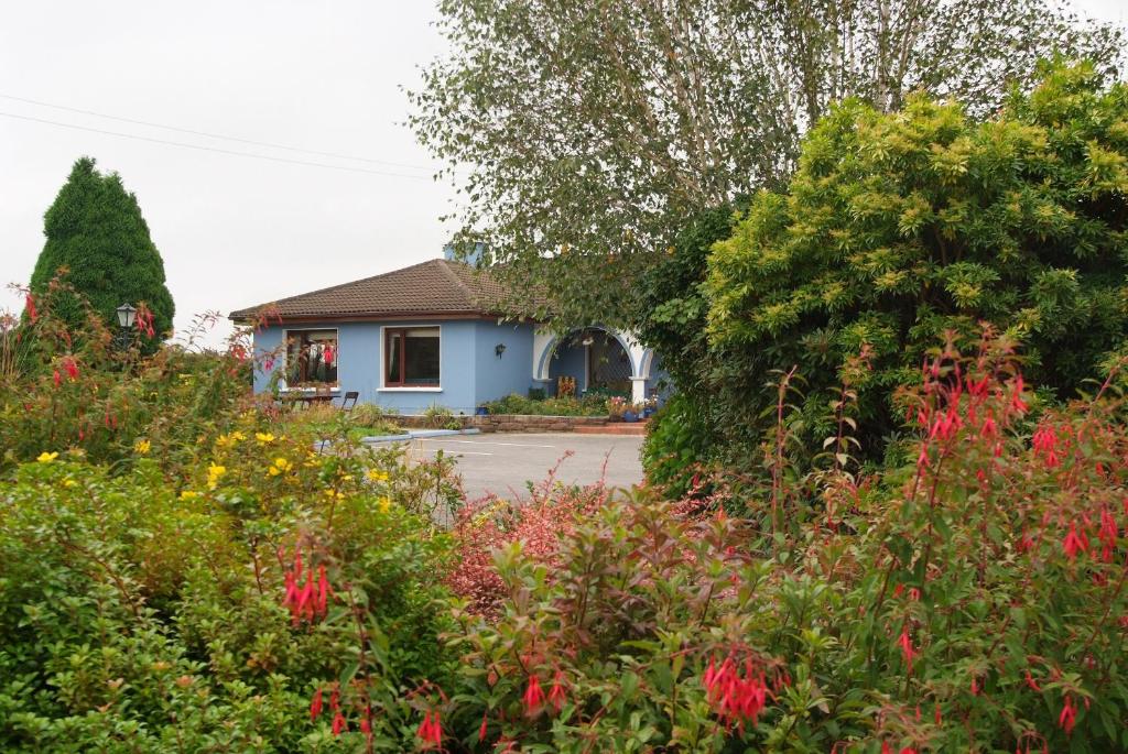 a house with a garden with flowers in front of it at Gormans Country Home in Killarney