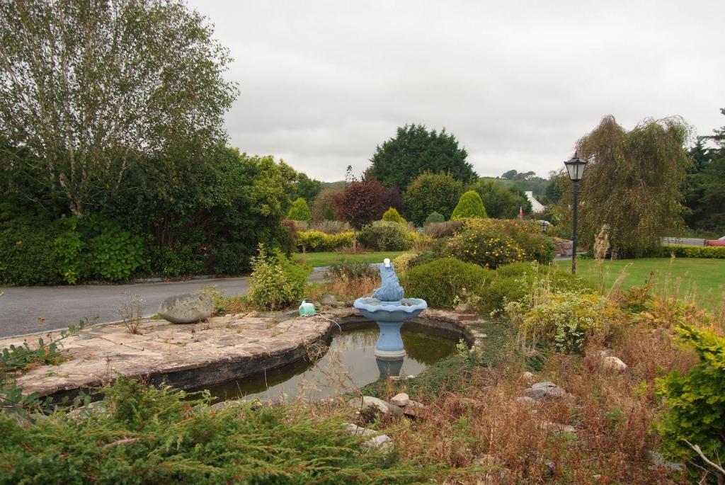 a garden with a statue in the middle of a pond at Gormans Country Home in Killarney