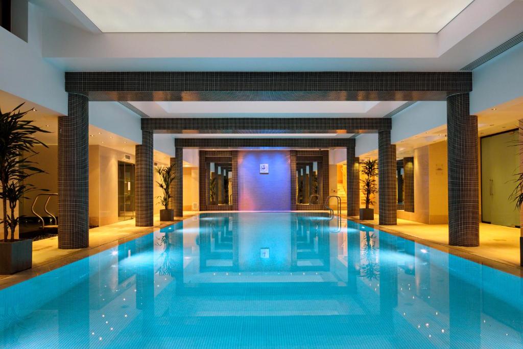 a large swimming pool in a hotel lobby at Leonardo Royal London St Paul’s in London