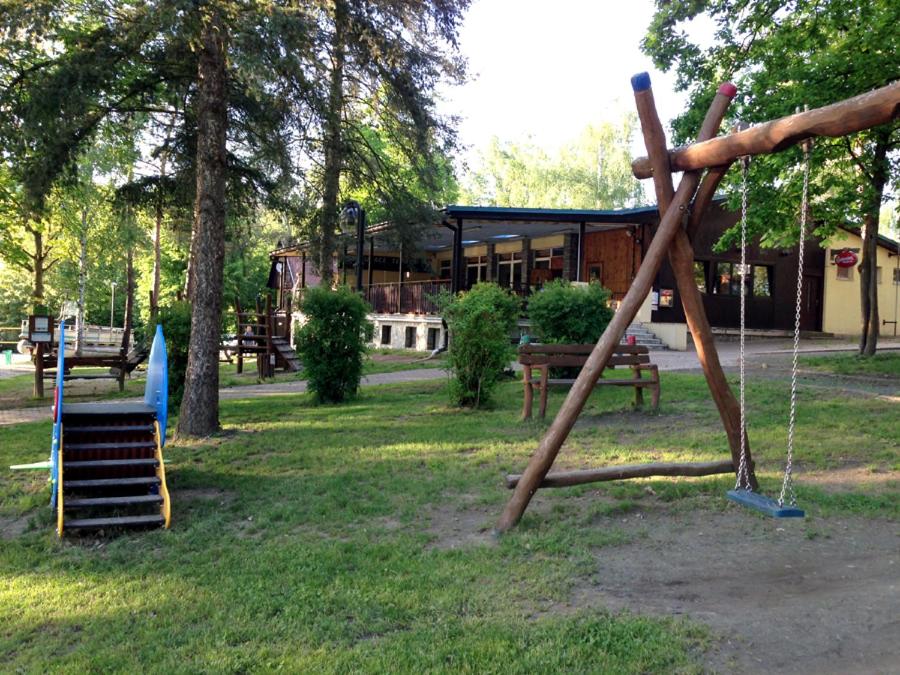 a playground with a swing set in a park at Resort Beach Nová Živohošť in Křečovice
