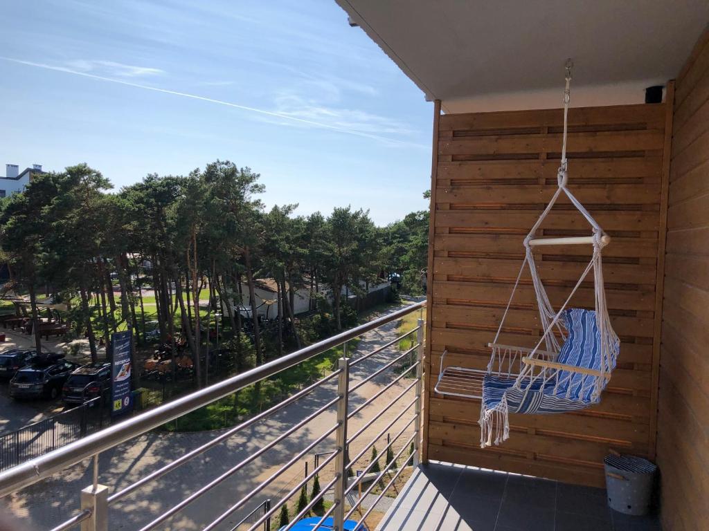 a balcony with a swing and a view of a street at apartament Wakacje w Rowach in Rowy