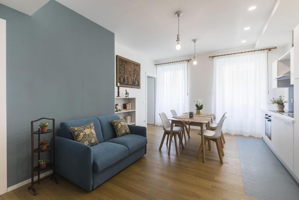 uma sala de estar com um sofá azul e uma mesa em Viaggio da Bea al Gianicolo em Roma