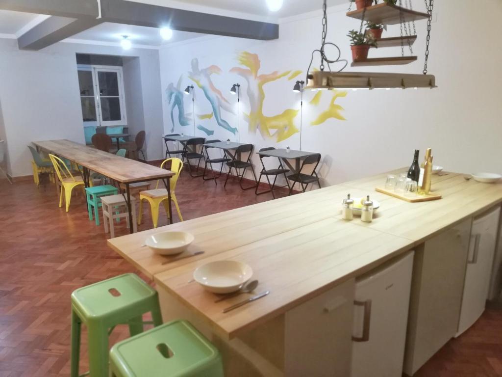 Draft Hostel & Rooms في لشبونة: مطبخ مع كونتر خشبي وبعض الطاولات والكراسي