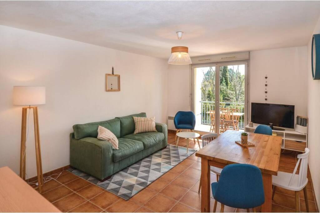 - un salon avec un canapé vert et une table dans l'établissement Appartement des amoureux, à Uzès