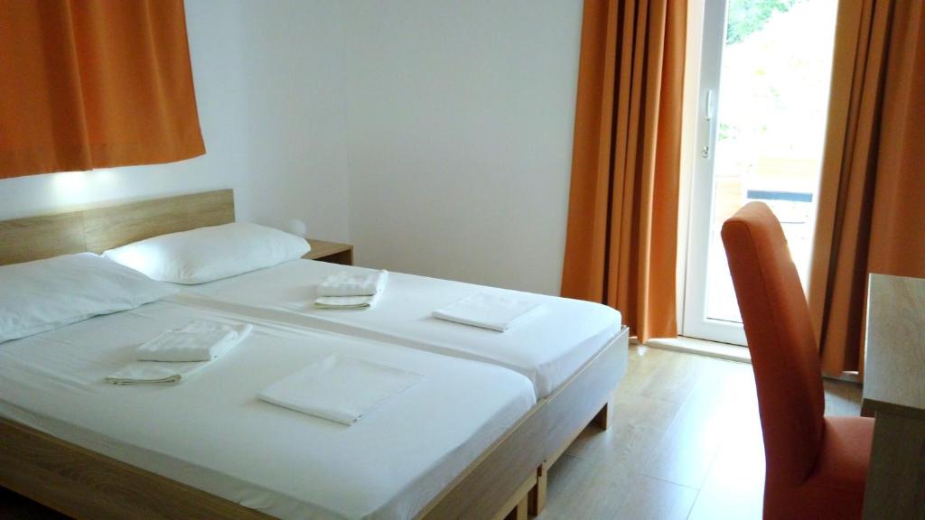 a white bed in a room with a window at Guest House Kukuljica 2 in Zaton