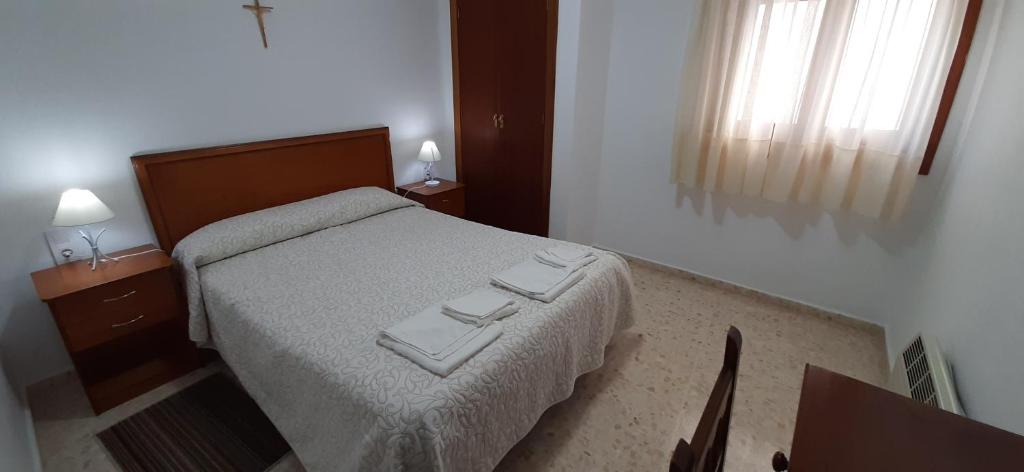 1 dormitorio con 1 cama y 2 toallas plegables. en Convento Madre de Dios de Carmona, en Carmona