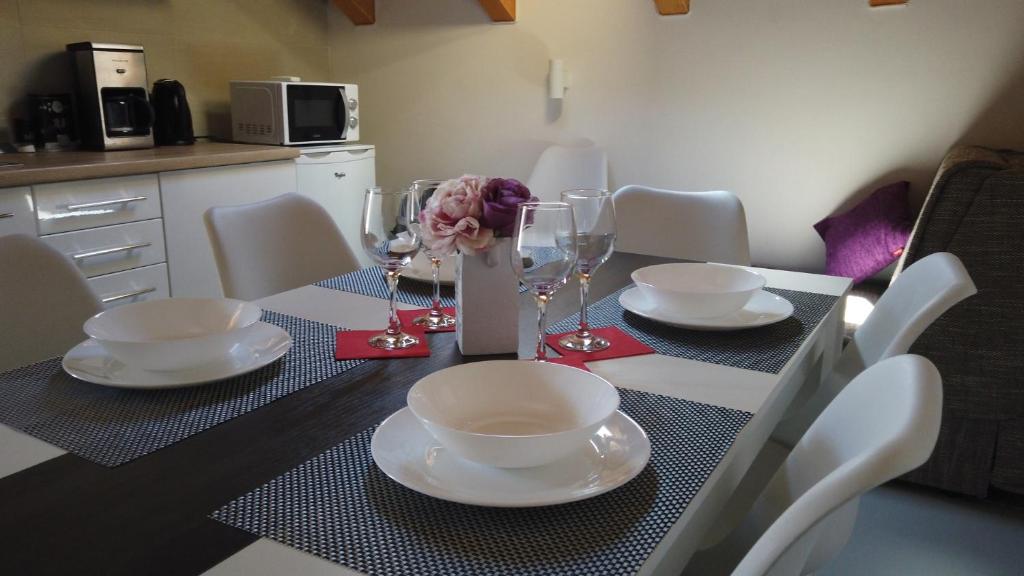 a dining room table with white plates and wine glasses at Guest House Kukuljica 2 in Zaton