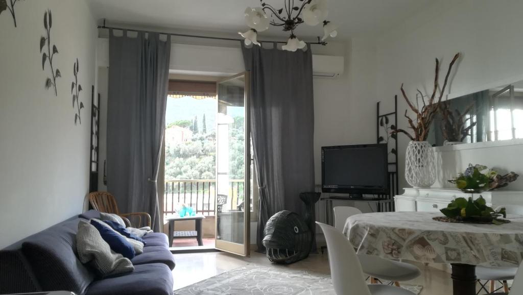 ein Wohnzimmer mit einem blauen Sofa und einem Tisch in der Unterkunft Alassio Mare e Non Solo 2 in Alassio