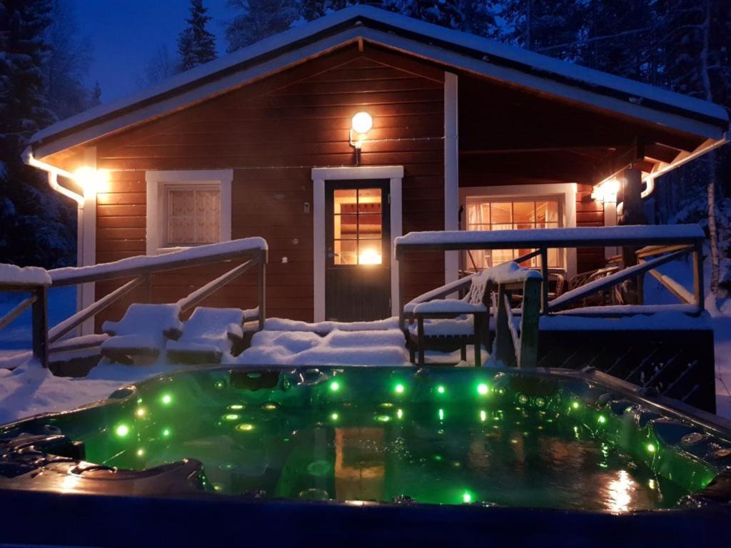 bañera de hidromasaje con luces de Navidad frente a una cabaña en Villa Vaskela, en Virrat