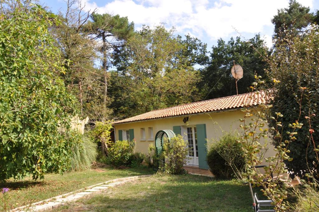 a small house in a garden with trees at Le clos de Cantemerle in Saint-Sauveur