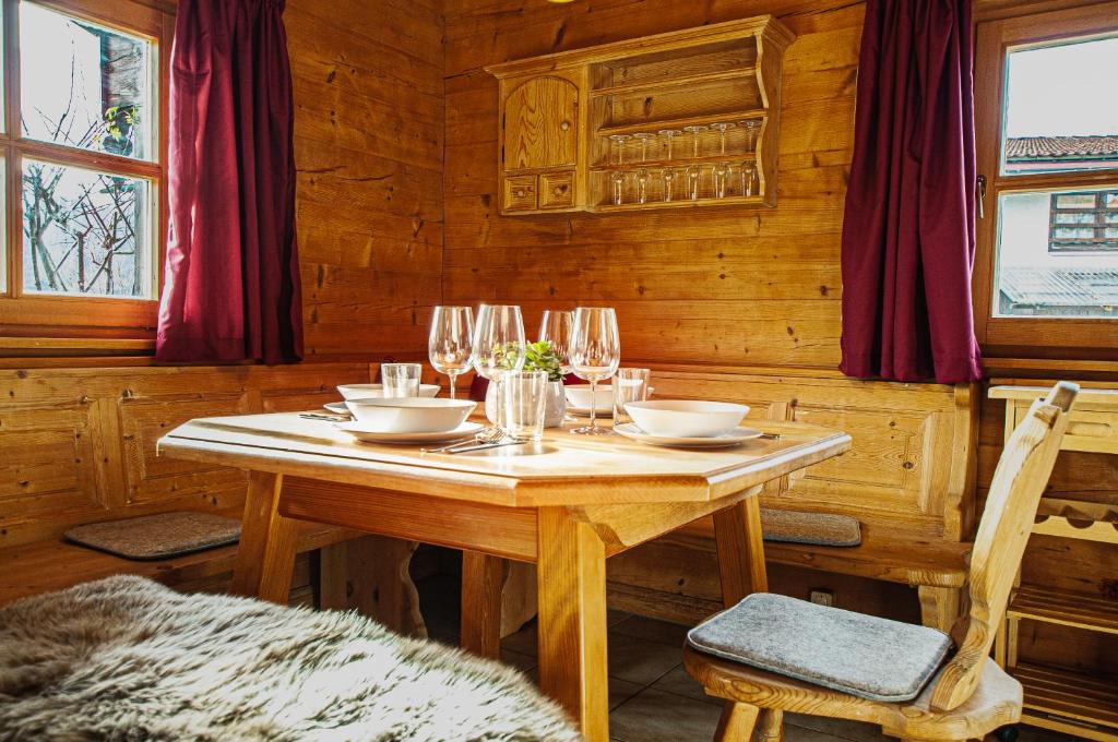 una mesa de madera con copas de vino. en Ruhige Chalets mit Seeblick in zentraler Lage en Schliersee