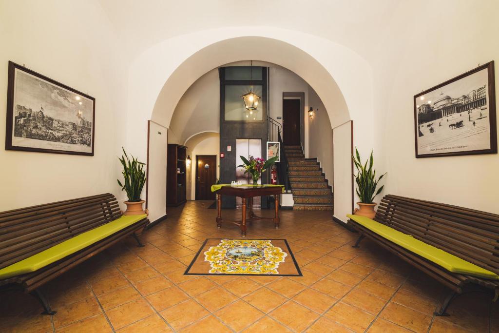 um corredor com dois bancos, uma mesa e escadas em La Marinella em Sorrento