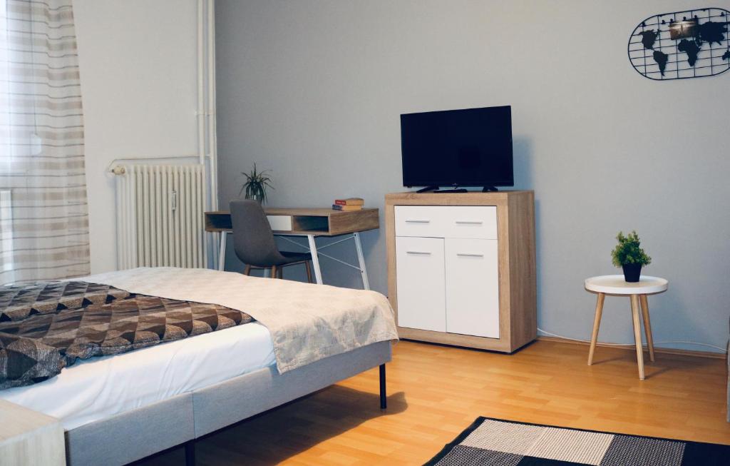 ペーチにあるHortenzia Apartman Pécsのベッドルーム1室(ベッド1台、デスク、テレビ付)