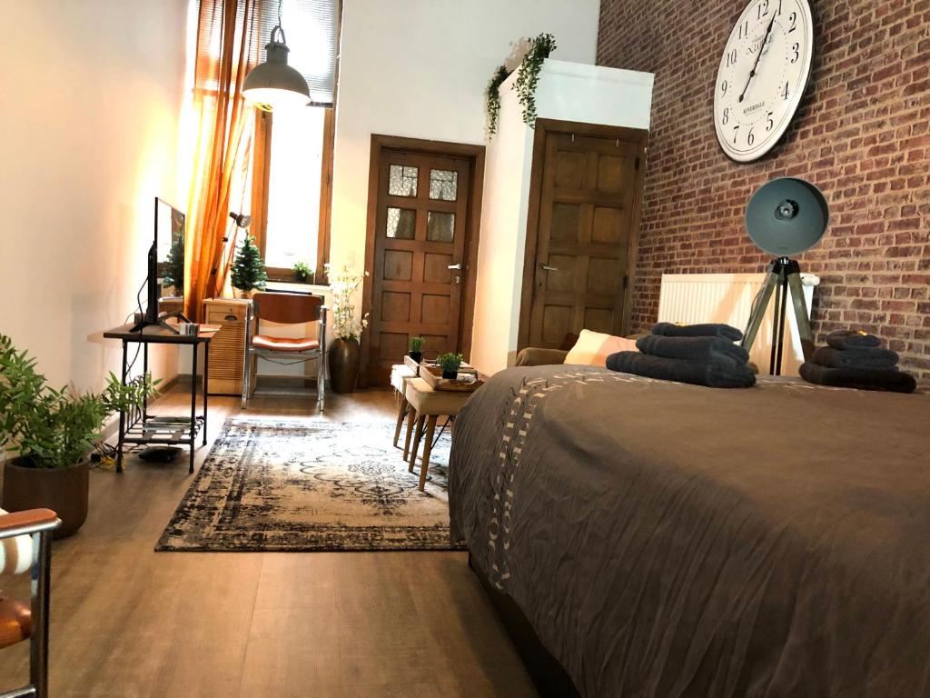 1 dormitorio con 1 cama y reloj en la pared en New York Loft - Fully equipped and available long-term - Perfect location IN city center, en Namur