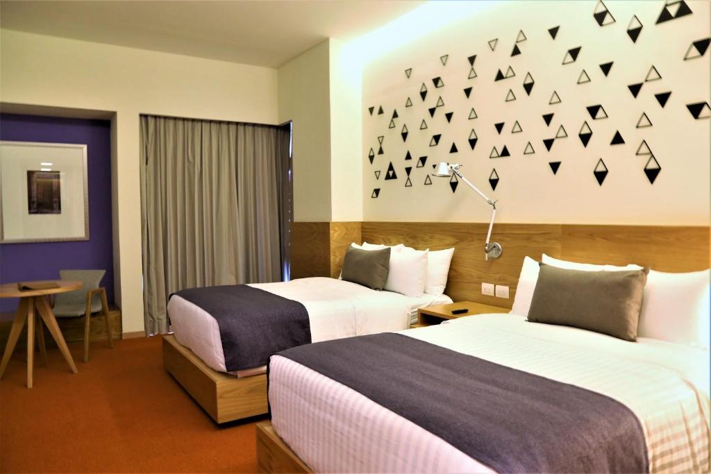 A bed or beds in a room at Hotel México Plaza Querétaro